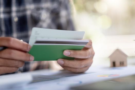 Man hands holding saving account passbook with calculator, account and saving for home loan concept.