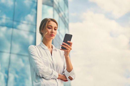 Businesswoman successful woman business person standing outdoor corporate building exterior cell phone Pensive elegance cute caucasian professional business woman middle age dreaming with mobile phone
