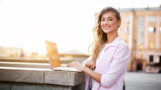 Businesswoman standing corporate building summer day using laptop Business person working remote Successful european caucasian woman freelancer make video call teacher study work online lessons