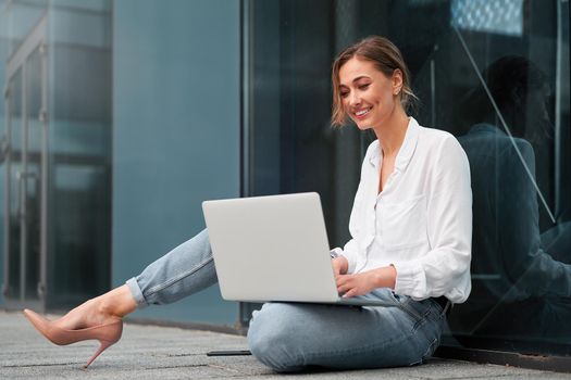 Businesswoman successful woman business person outdoor corporate building exterior with laptop Pensive elegance cute caucasian professional business woman middle age ecommerce deal Online banking