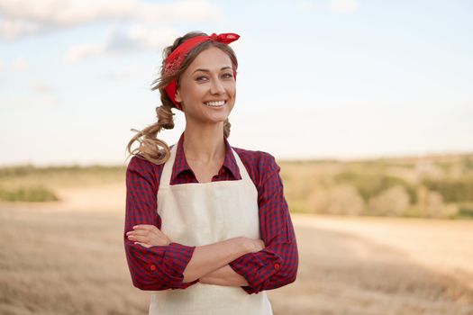 Woman farmer apron standing farmland smiling Female agronomist specialist farming agribusiness Happy positive caucasian worker agricultural field Pretty girl arms crossed dressed red checkered shirt