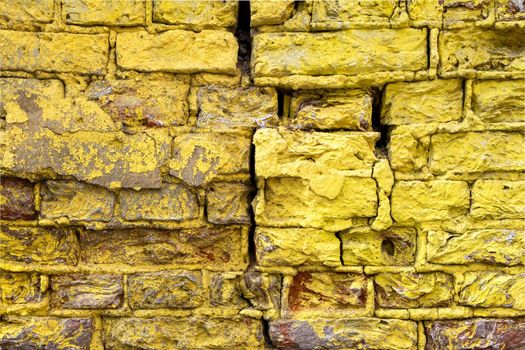 Close-up of a fragment of an old wall with bright yellow brickwork.