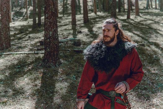 Viking with an angry look on his face in a Norwegian forest.