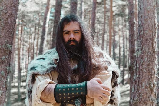 Viking with an angry look on his face in a Norwegian forest.