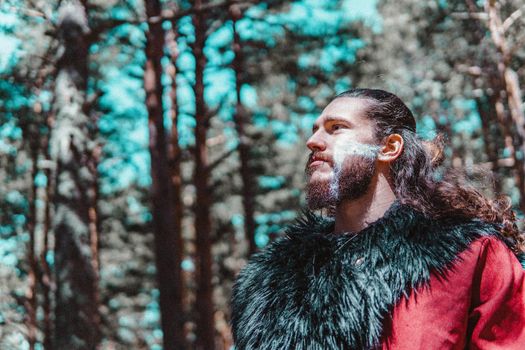 Viking with war paintings in a Norwegian forest