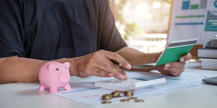 Young Asian woman checking bills, taxes, bank account balance and calculating credit card expenses. Family expenses concept..