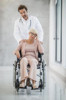 Shot of a young doctor caring a senior female patient in a wheelchair.
