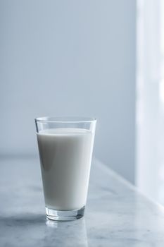 Dairy, healthy nutrition and breakfast concept - World Milk Day, full glass on marble table