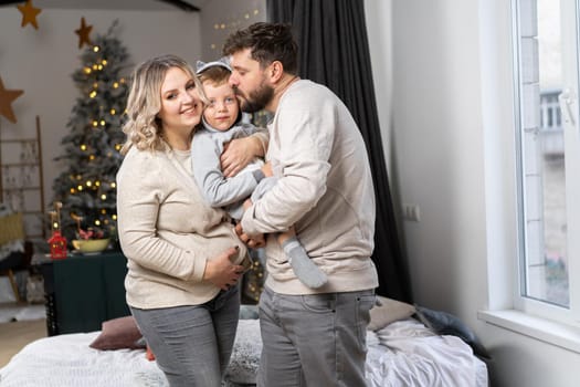 Happy family concept Mother father and little son have fun at home Caucasian family indoors Pregnant mom beard dad and funny little boy
