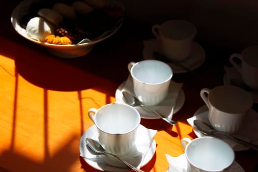 Coffee cups on the table lit by the sun