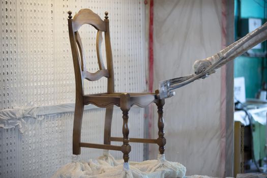 Covering the chair with lacquer.Painting chairs in the factory