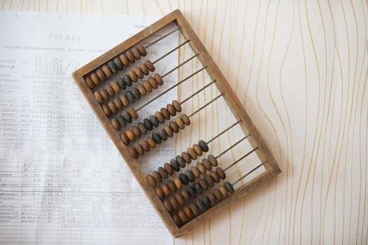 Wooden abacus on the wall with paper chart