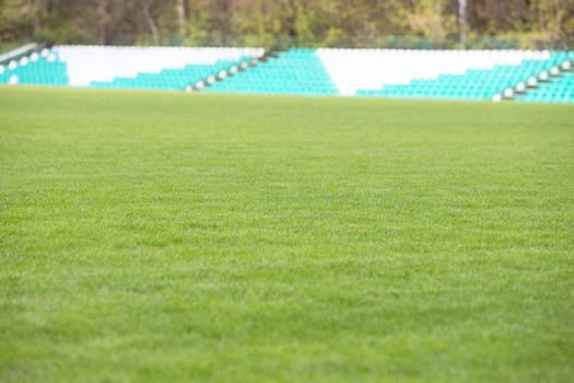 Green lawn with blurred spectator stands