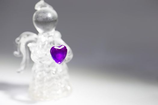 Glass angel with a purple heart closeup