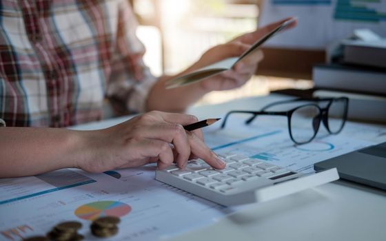 Young asian woman checking bills, taxes, bank account balance and calculating credit card expenses. Family expenses concept..