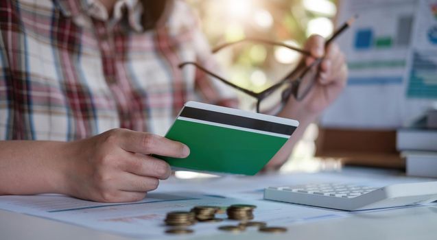 Young asian woman checking bills, taxes, bank account balance and calculating credit card expenses. Family expenses concept..