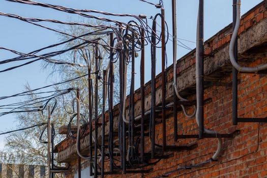 lots of wires sticking out of an old brick electrical substation building at daylight