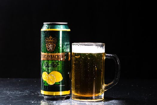 Can of Perlenbacher Radler beer and beer glass on dark background. Illustrative editorial photo shot in Bucharest, Romania, 2021