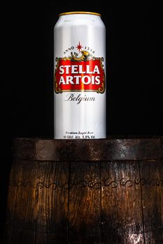 Can of Stella Artois beer on beer barrel with dark background. Illustrative editorial photo Bucharest, Romania, 2021
