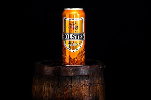 Can of Holsten beer on beer barrel with dark background. Illustrative editorial photo shot in Bucharest, Romania, 2021