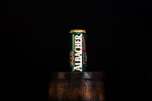 Can of Albacher beer on beer barrel with dark background. Illustrative editorial photo shot in Bucharest, Romania, 2021