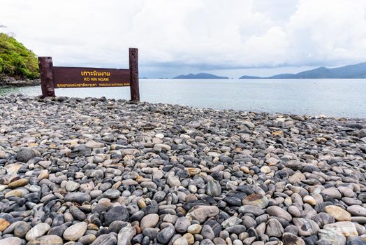 Place name plate of Ko Hin Ngam island and beautiful nature landscape of unusual rock near the sea in summer is a famous tourist attractions of Tarutao National Park, Satun, Thailand