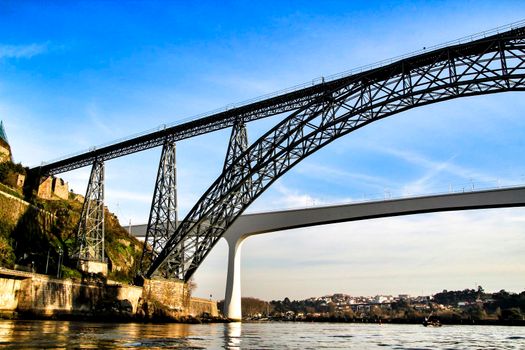 Beautiful and colossal iron bridge called Dom Luis I over the waters of the Douro River in Porto
