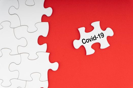 COVID-19 text with jigsaw puzzle on red background. Covid-19 and Coronavirus Concept