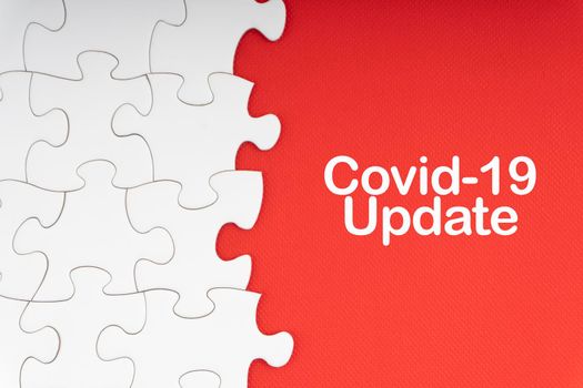 COVID-19 UPDATE text with jigsaw puzzle on red background. Covid-19 and Coronavirus Concept