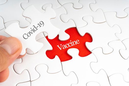 COVID-19 VACCINE text with jigsaw puzzle on red background. Covid-19 and Coronavirus Concept