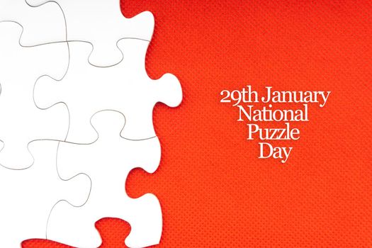NATIONAL PUZZLE DAY  text with jigsaw puzzle on red background. Education and Holiday Concept
