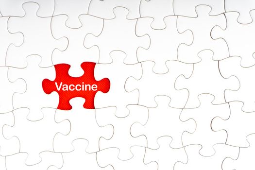 VACCINE text with jigsaw puzzle on red background. Covid-19 and Coronavirus Concept