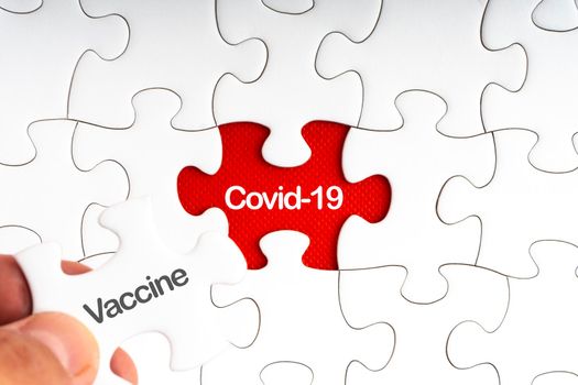 COVID-19 VACCINE text with jigsaw puzzle on red background. Covid-19 and Coronavirus Concept