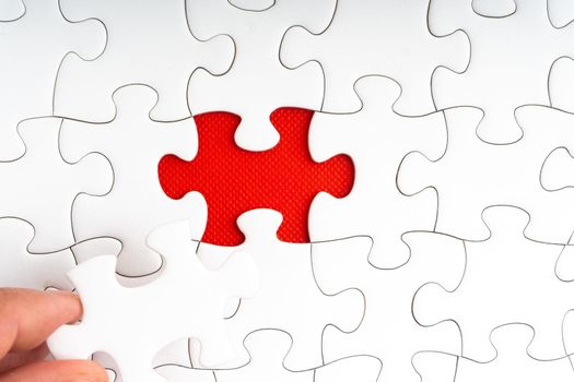Hands holding Red jigsaw puzzle pieces on red background. Copy space and business concept