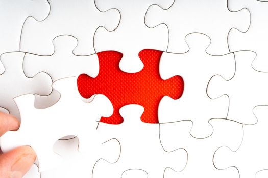 Hands holding jigsaw puzzle pieces on red background. Copy space and business concept