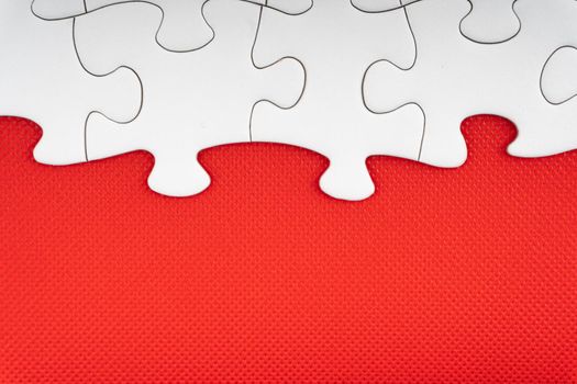 Jigsaw puzzle pieces on red background. Copy space and business concept
