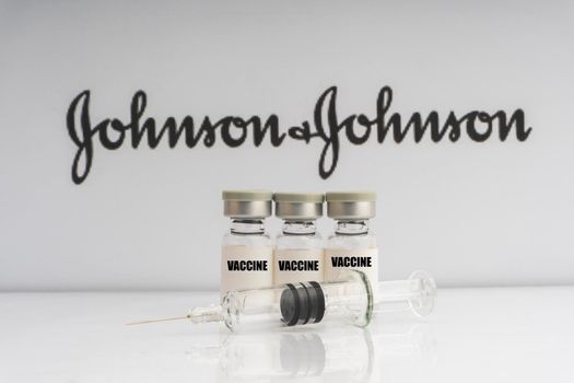 Kuala Lumpur, Malaysia - Mac 2, 2021: Vials vaccine and syringe on blurry Johnson & Johnson background. Selective focus 