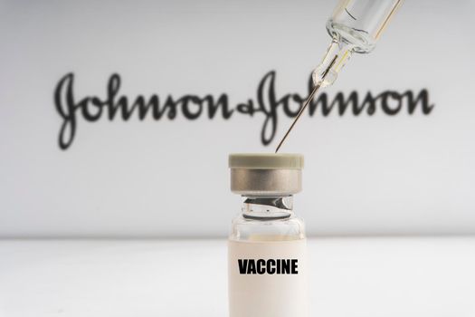 Kuala Lumpur, Malaysia - Mac 2, 2021: Vials vaccine and syringe on blurry Johnson & Johnson background. Selective focus 