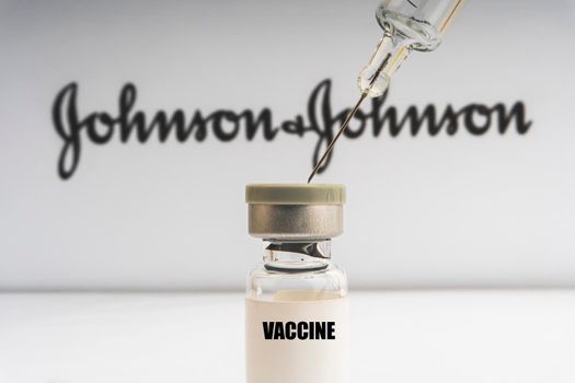 Kuala Lumpur, Malaysia - Mac 2, 2021: Vials vaccine and syringe on blurry Johnson & Johnson background. Selective focus 