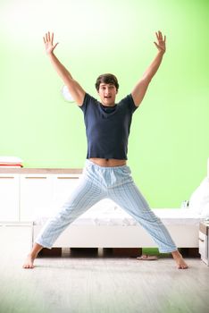 Young man in pajamas doing morning exercises 