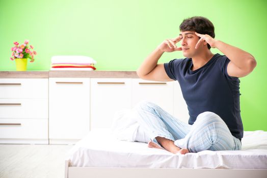 Young man in pajamas doing morning exercises 