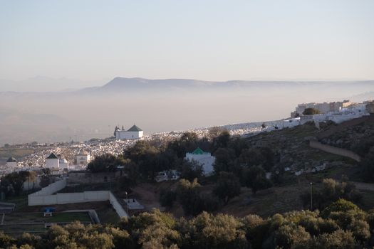 Bab Mahrouk Cemetery Fes Morocco historically the main western city gate of Fes el Bali, the old walled city with atmospheric mist and mountains behind . High quality photo