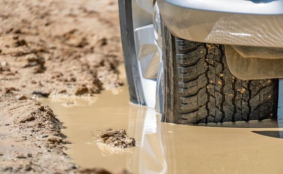 Suv 4wd car rides through deep muddy puddle