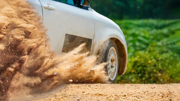 Rally race car drifting on dirt track.