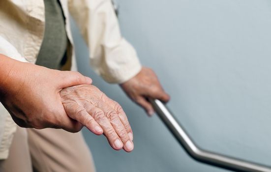 Elderly woman holding on handrail with caregiver