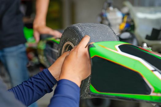 Go kart front wheel with racing tire in service station