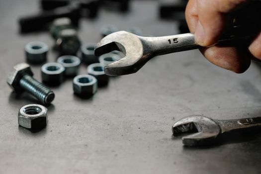 Close up automotive mechanic picking tools in garage