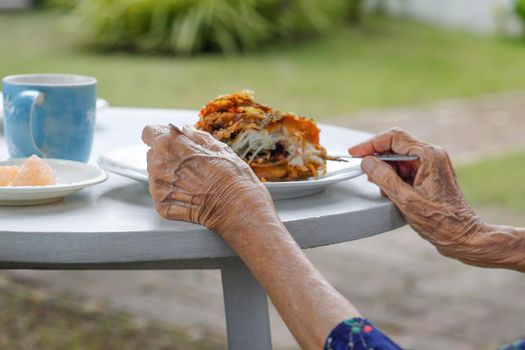 elderly woman have breakfast in backyard