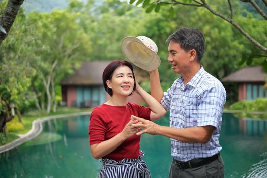 Asian middle aged man relaxing with his wife in anniversary wedding day