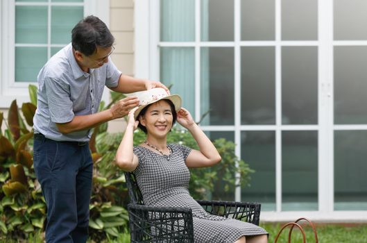 Asian middle aged couple sitting and relax in backyard